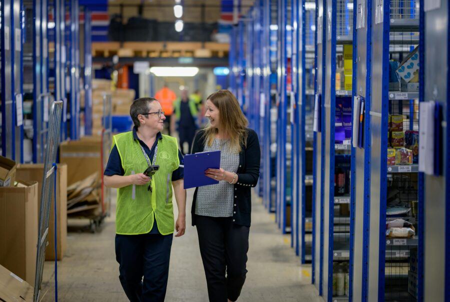 twee vrouwen die samen door een magazijn lopen na een inventarisatie
